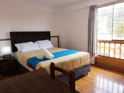 a bedroom with a bed and a large window at Anata Hotel in Cusco