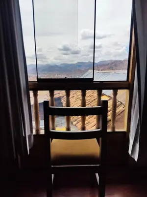 a chair sitting in a room looking out a window at Anata Hotel in Cusco
