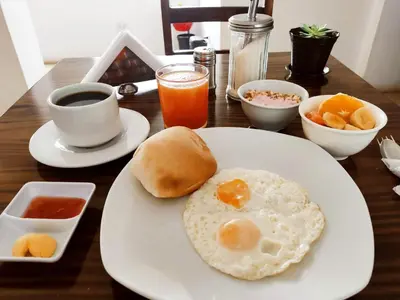 a plate with a fried egg on a table at Anata Hotel in Cusco