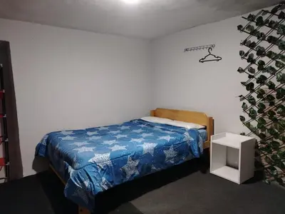 a bedroom with a bed with a blue blanket at CASa HOSPEDAJE RODRÍGUEZ in Urubamba