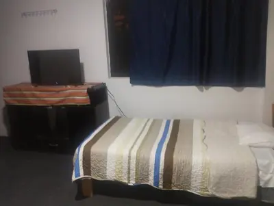 a bedroom with a bed and a television and a window at CASa HOSPEDAJE RODRÍGUEZ in Urubamba