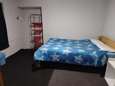 a bedroom with a bed with a blue blanket at CASa HOSPEDAJE RODRÍGUEZ in Urubamba