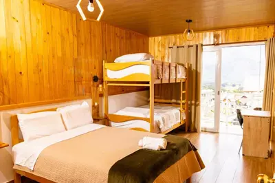 a bedroom with two bunk beds and a window at Colina Haus, cabaña familiar Oxa in Oxapampa