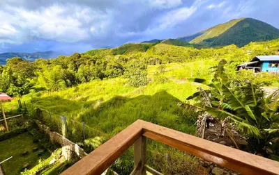a view of a green hill with mountains in the background at Colina Haus, cabaña familiar Oxa in Oxapampa