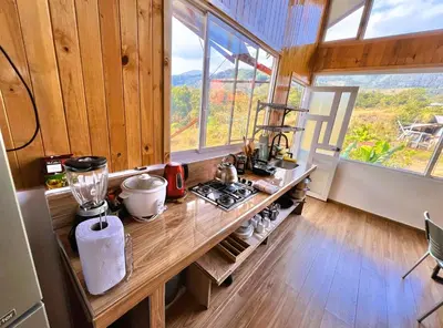 a kitchen with a wooden counter with a window at Colina Haus, cabaña familiar Oxa in Oxapampa