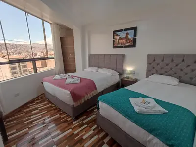 a hotel room with two beds and a large window at Templo Home in Cusco