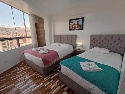 a hotel room with two beds and a window at Templo Home in Cusco