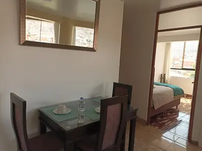 a dining room with a table and a bed and a mirror at Templo Home in Cusco