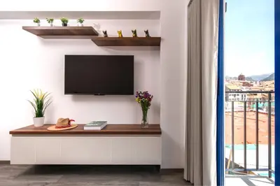 a living room with a tv on a wall at Cozy modern heart of city in Cusco