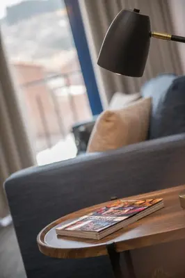 a lamp on a table next to a couch at Cozy modern heart of city in Cusco