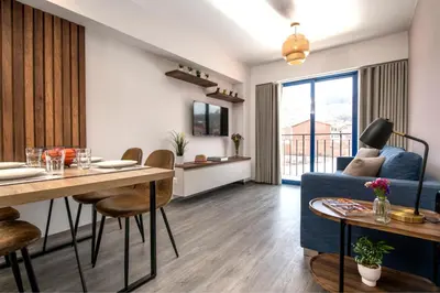 a living room with a table and a blue couch at Cozy modern heart of city in Cusco