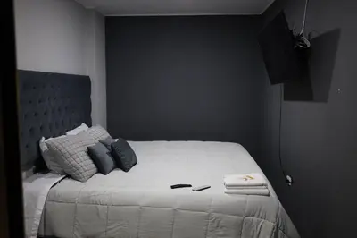 a bedroom with a white bed with blue pillows at Casa sabina aeropuerto entera in Lima