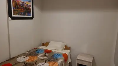 a small bed in a room with a picture on the wall at Samay Ñawi Wasi in Cusco