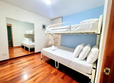 a bedroom with two bunk beds and a wooden floor at FlatTOP San Isidro City View Lima 3B 1804 in Lima