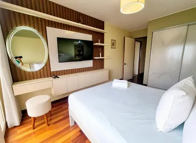 a bedroom with a white bed and a mirror at FlatTOP San Isidro City View Lima 3B 1804 in Lima