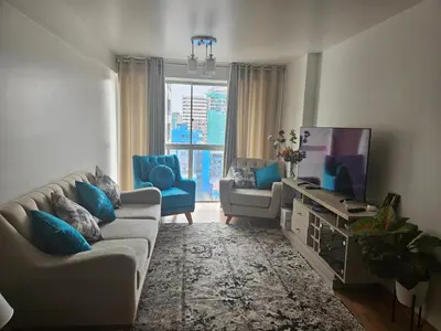 a living room with a couch and a tv at Flat Arenales in Lima