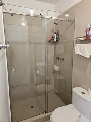 a bathroom with a glass shower with a toilet at Flat Arenales in Lima