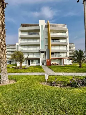 a large white building with a lawn in front of it at Suite 1ra Fila Vista Bahía Paracas - Sotavento 601 T3 in Paracas