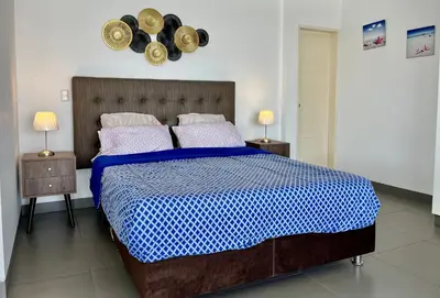 a bedroom with a blue and white bed with two night stands at Suite 1ra Fila Vista Bahía Paracas - Sotavento 601 T3 in Paracas