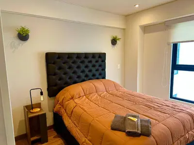 a bedroom with a bed and two plants on the wall at San Isidro, lindo depa , 2tv wifi, piscina, lavanderia in Lima