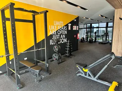 a gym with machines and a yellow wall at San Isidro, lindo depa , 2tv wifi, piscina, lavanderia in Lima