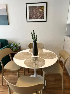 a table and chairs with a vase on top of it at San Isidro, lindo depa , 2tv wifi, piscina, lavanderia in Lima