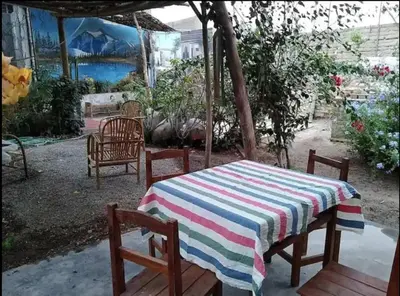 a table with a striped table cloth and two chairs at Hermanas Pimentel in Ica