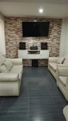 a living room with two couches and a flat screen tv at Departamento Duplex Aeropuerto y plaza cerca de ti! in Lima