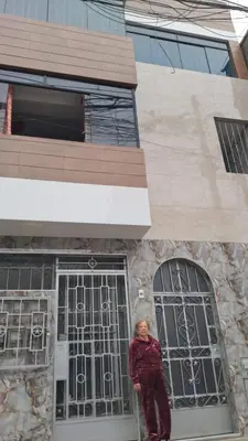 a woman standing in front of a building at Departamento Duplex Aeropuerto y plaza cerca de ti! in Lima