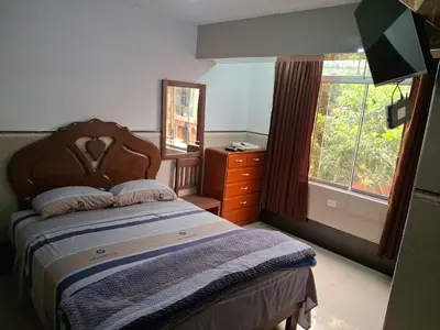 a bedroom with a bed and a dresser and a window at HOSPEDAJE JOVITa in Lima