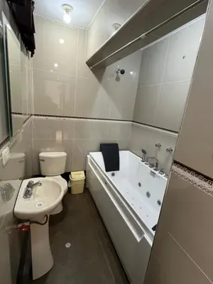 a bathroom with a tub and a toilet and a sink at HOSPEDAJE JOVITa in Lima