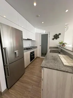 a kitchen with a stainless steel refrigerator and wooden floors at Departamento de lujo Miraflores con Aire Acondicionado in Lima