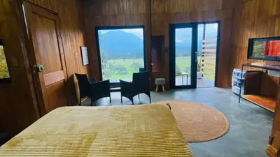 a bedroom with a bed and a table and chairs at Cabaña1 con hermosa vista al valle in Oxapampa