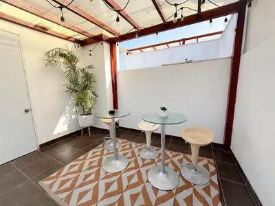a room with two tables and two stools at Apartamento exclusivo con terraza privada in Lima