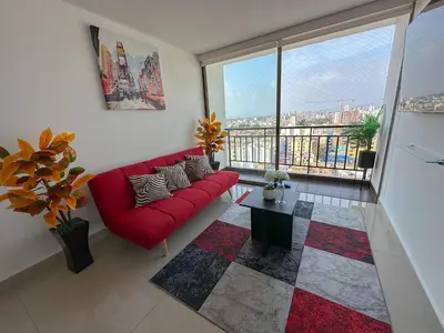 a living room with a red couch and a large window at Apartamento exclusivo con terraza privada in Lima