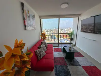 a living room with a red couch and a large window at Apartamento exclusivo con terraza privada in Lima