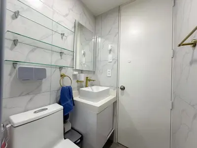 a white bathroom with a toilet and a sink at Apartamento exclusivo con terraza privada in Lima