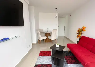a living room with a red couch and a table at Apartamento exclusivo con terraza privada in Lima