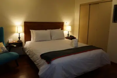 a bedroom with a large white bed with two lamps at Atrium Miraflores Hotel in Lima