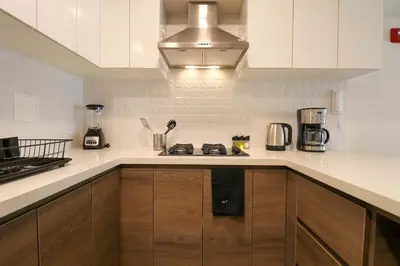 a kitchen with white cabinets and a stove top oven at Artline in Barranco by Wynwood House in Lima