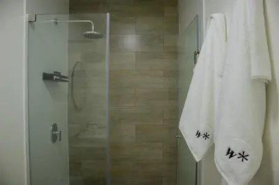a shower with a glass door and a towel at Artline in Barranco by Wynwood House in Lima
