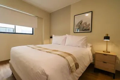 a bedroom with a large white bed and a window at Treehouse by Wynwood house in Lima