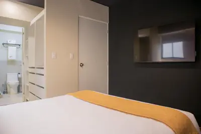 a bedroom with a bed and a tv on the wall at Treehouse by Wynwood house in Lima