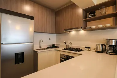 a kitchen with wooden cabinets and a refrigerator at Treehouse by Wynwood house in Lima