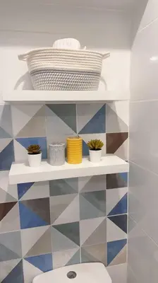 a bathroom with a toilet and a shelf with plants at Premium Loft-Moderno y Acogedor in Lima