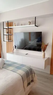 a bedroom with a bed with a tv on the wall at Premium Loft-Moderno y Acogedor in Lima