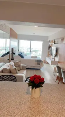 a living room with a couch and a vase with red flowers at Premium Loft-Moderno y Acogedor in Lima