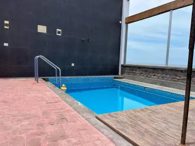 a swimming pool next to a building at Ali Home in Punta Negra