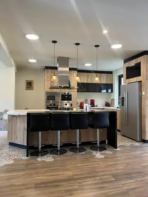 a kitchen with a large island with black bar stools at Casa El Oasis de Ica in Ica