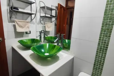 a bathroom with two green bowls on a sink at Casa de 4 pisos cerca a embajada de USA y centros comerciales in Lima